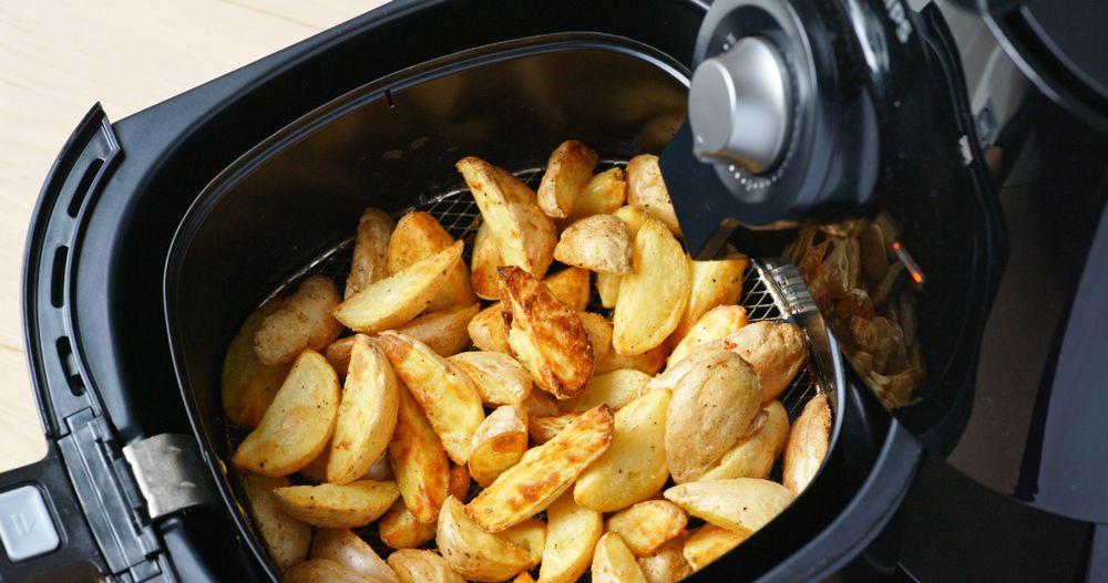 A top down view of home fries within an air fryer