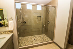 A close up of a walk-in shower inside of a white-colored bathroom