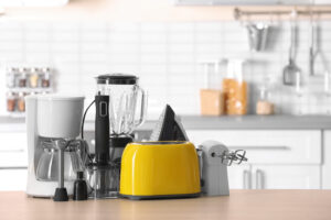 An assortment of kitchen appliances rests on a kitchen countertop