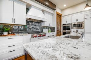 A kitchen with quartz countertops and a gray backsplash